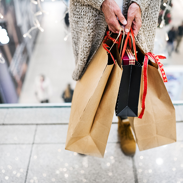 Person shopping holding holiday gift bags